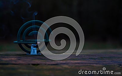 Burning of the mosquito coil in nature. Mosquito-repelling incense with a whiff of smoke, banner, copy space Stock Photo