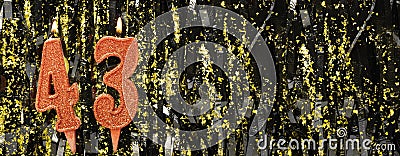 Burning red birthday candles on glitter tinsel background, number 43. Banner. Stock Photo