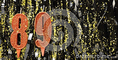 Burning red birthday candles on glitter tinsel background, number 89. Banner. Stock Photo