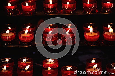 Burning red candles in a church Stock Photo