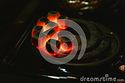 Burning red coals for hookah, heated on the stove Stock Photo