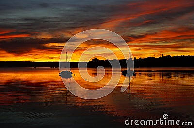 burning red sunset on lake Ammersee with sailing boats resting on the water (Herrsching in Germany) Editorial Stock Photo