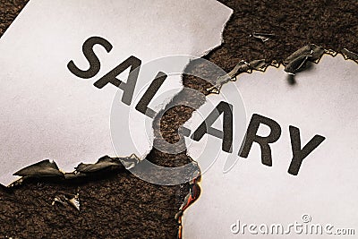 A burning sheet of paper is torn in half. Inscription salary burns out Stock Photo