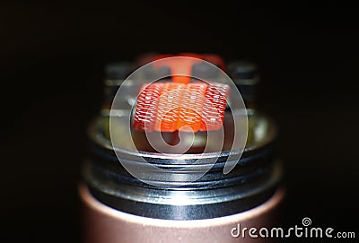 Burning staple staggered fused clapton coil in rebuildable dripping atomizer Stock Photo