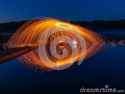 Burning steel wool spinning, showers of glowing sparks from spinning steel wool Stock Photo