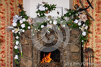 Burning stone fireplace decorated for Christmas. Stock Photo