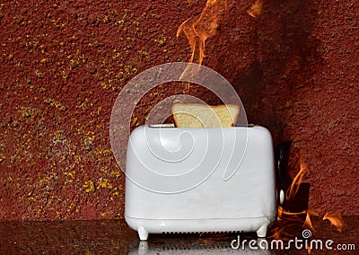 Burning toaster. Toaster with toast caught on fire over table Stock Photo