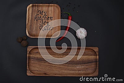 Burning on a wooden plate on a background of black garlic and hot red pepper Stock Photo