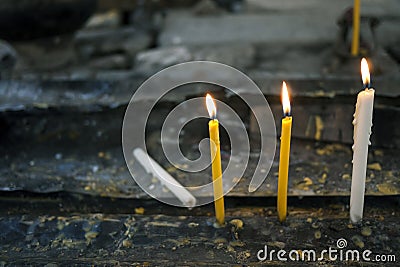 Burning yellow and white candle Stock Photo