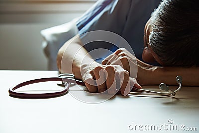 A burnout doctor feeling tired in medical office Stock Photo