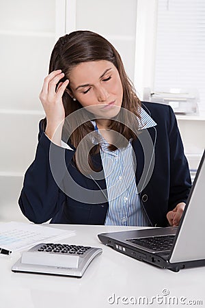 Burnout: overworked tired businesswoman in blue scratching head Stock Photo