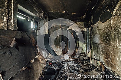 Burnt apartment house interior. Burned furniture and charred walls in black soot Stock Photo