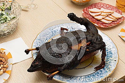 Burnt bird carcass on serving plate on dining table. Serve charred spoiled dish. Lousy housewife and bad chef. Delicious Stock Photo