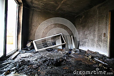 Burnt and destroyed room with bright daylight coming from balcony door Stock Photo