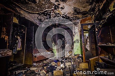 Burnt mansion. Burned furniture, door, charred walls and ceiling Stock Photo