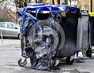 Burnt and melted trash can form a fire. Stock Photo