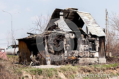 The burnt out country house is one floor, a lonely charred building. Arson Cottage, black windows, broken walls, burnt Stock Photo