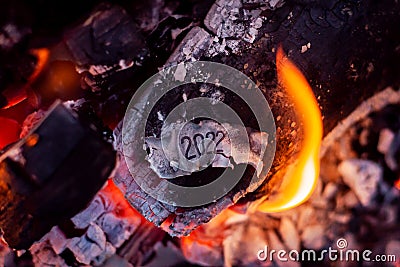 Burnt paper with inscription 2022 in campfire Stock Photo