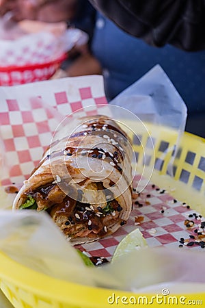 Burrito covered with sauce and seeds on a plastic basket Stock Photo