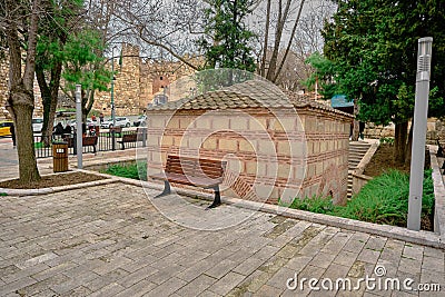 Somuncu baba tomb near the old entrance gate of Bursa saltanat kapisi with single public bench made of wooden material and peopl Editorial Stock Photo