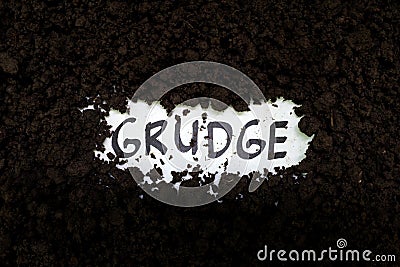 Bury grudge and stop holding concept. Grudge text word on soil backdrop. Stock Photo