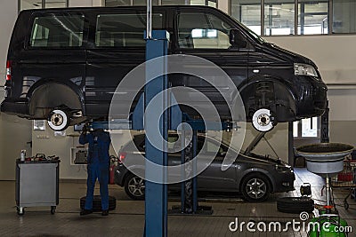 Bus, car raised on a hydraulic jack. Suspension repair, tire change Editorial Stock Photo