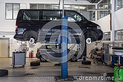 Bus, car raised on a hydraulic jack. Suspension repair, tire change Editorial Stock Photo