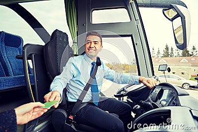 Bus driver taking ticket or card from passenger Stock Photo