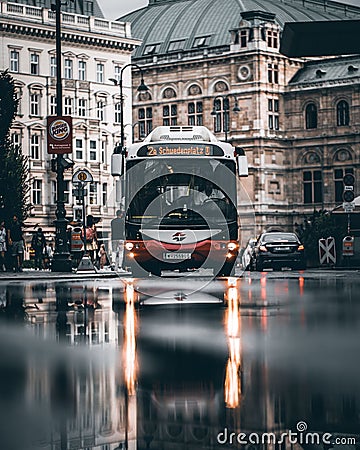 Bus driving in street of Vienna City to Schwedenplatz and the ground is wet from rain in Austria Editorial Stock Photo