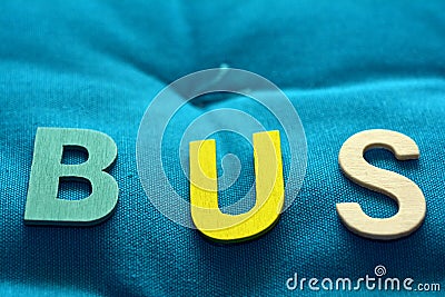 BUS, word with wooden letters on background with colored cloth Stock Photo