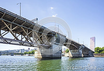 Buscle Burnside Bridge with big support columns and truss roadbed across Willamette River in Portland Oregon Stock Photo
