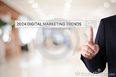 Businesman hand touching 2024 digital marketing trends search bar over blur office background, banner, SEO 2024 business trends Stock Photo