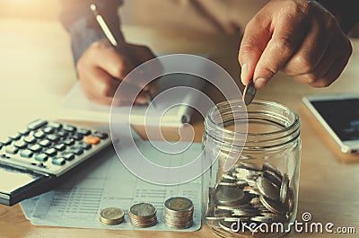 business accountin with saving money with hand putting coins in Stock Photo