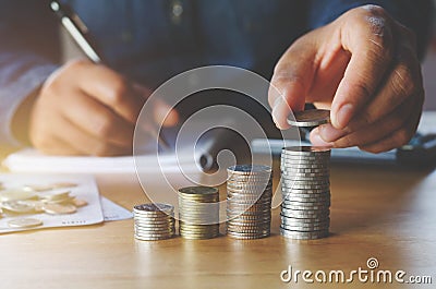 business accounting with saving money with hand putting coins on Stock Photo