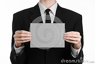 Business and advertising topic: Man in black suit holding a gray blank card in hand isolated on white background in studio Stock Photo