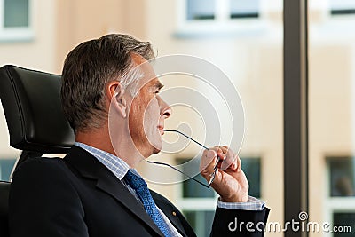 Business - Boss contemplating in his office Stock Photo
