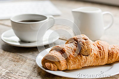 Business breakfast in office with coffee, milk and croissant on wooden table background Stock Photo