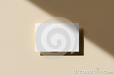 Business card mockup on a beige background with shadow overlay. 85x55 mm Stock Photo