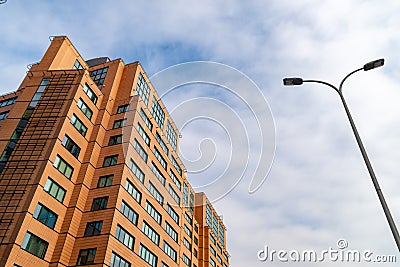 Business center. Red brick building with green windows against the sky. Stock Photo