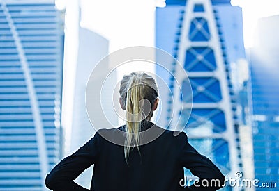 Business challenge. Confident businesswoman overlooking the city center high-rises Stock Photo