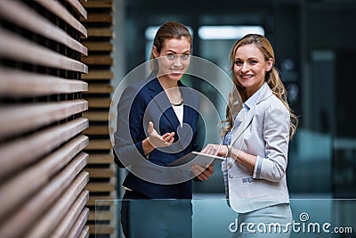 Business colleagues using digital tablet in office lobby Stock Photo