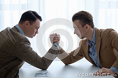 Business competition arm wrestling focused men hands Stock Photo