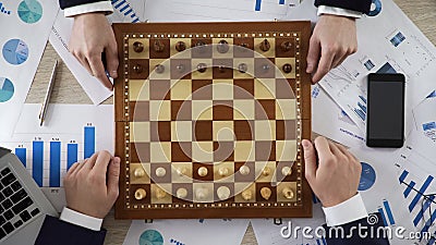 Business competitors playing chess game, company taking strategic step on market Stock Photo