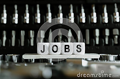 Against the background of a set of tools, white cubes with the inscription - Jobs Stock Photo