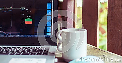 Chart of trading maket on laptop with coffee cup Stock Photo
