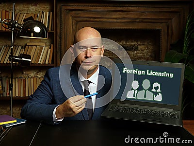 Business concept about Foreign Licensing with sign on laptop in hand Stock Photo