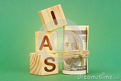On a green surface, dollars and cubes with the inscription - IAS Stock Photo