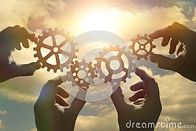 Business concept idea. four hands of businessmen collect a puzzle from gears. Stock Photo