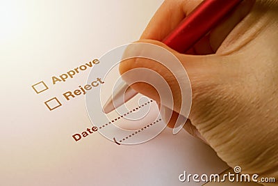 Hand Holding Pen to Sign on Approve or Reject on Document Stock Photo