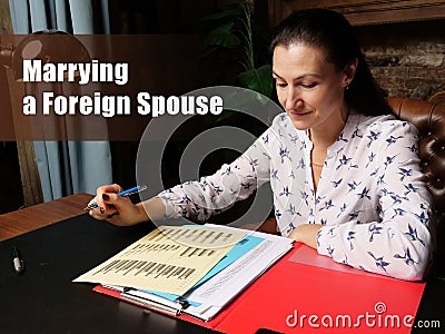 Business concept about Marrying a Foreign Spouse Female office workers with yellow shirt holding and writing documents on office Stock Photo